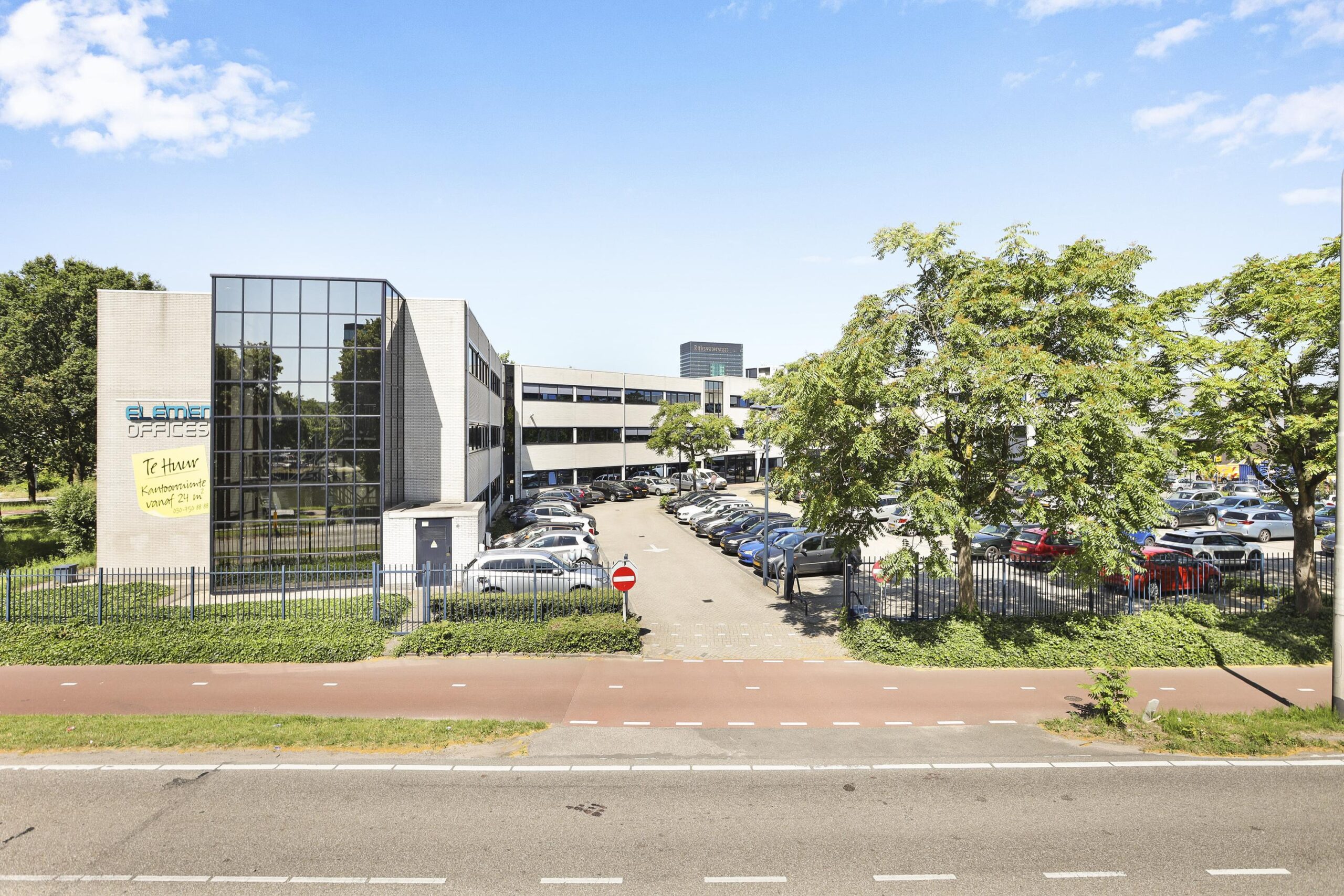 Vooraanzicht van een modern kantoorgebouw met parkeerplaatsen aan de Winthontlaan.