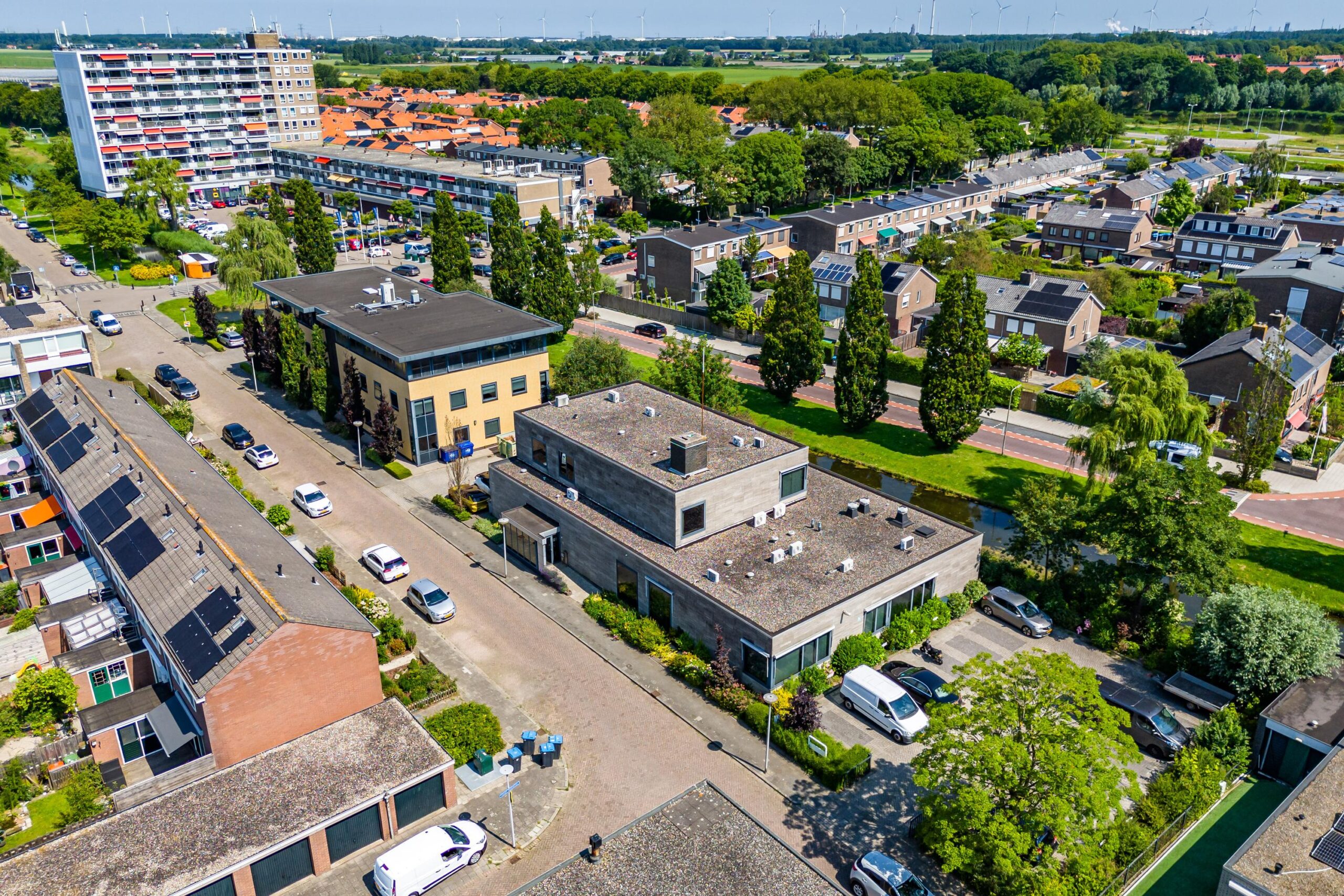 Luchtfoto van de Nicolaas Pieckstraat, met diverse gebouwen, auto's en een groene omgeving.