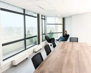 Moderne kantoorruimte aan de Pascallaan 60-78 in Lelystad met vergadertafel, grote ramen en een zithoek.