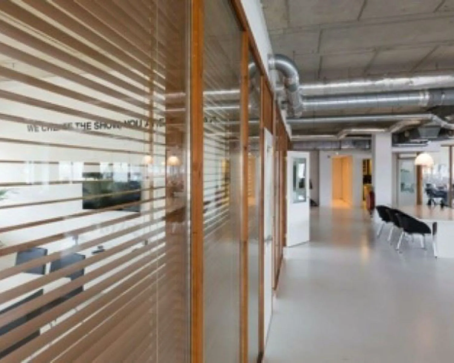 Moderne kantoorruimte met glazen wanden, vergadertafel en industriële plafonddetails aan de Anthony Fokkerweg 21 in Amsterdam.