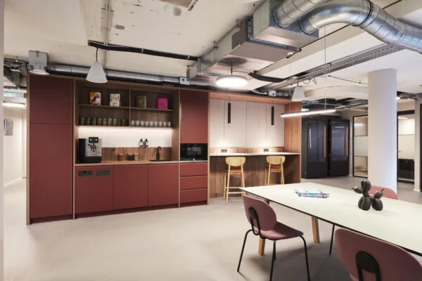 Moderne kantoorkeuken met zithoek aan de Koninginnegracht 10 in Den Haag, ingericht met stijlvolle meubels en industriële details.