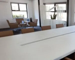 Moderne kantoorruimte met vergadertafel en zithoek aan de Arlandaweg 92 in Amsterdam.