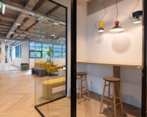 Moderne kantoorruimte in het Coengebouw aan de Kabelweg 37 in Amsterdam met kleurrijk interieur en zithoeken.