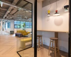 Moderne kantoorruimte in het Coengebouw aan de Kabelweg 37 in Amsterdam met kleurrijk interieur en zithoeken.