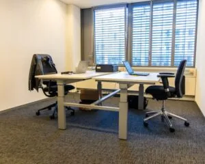 Moderne kantoorruimte met twee bureaus en bureaustoelen aan de Gaetano Martinolaan 75-95 in Maastricht.