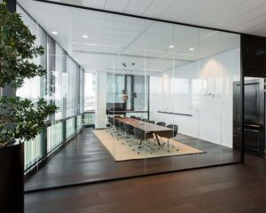 Moderne vergaderruimte met glazen wanden en lange houten tafel aan de Herikerbergweg 292 in Amsterdam.