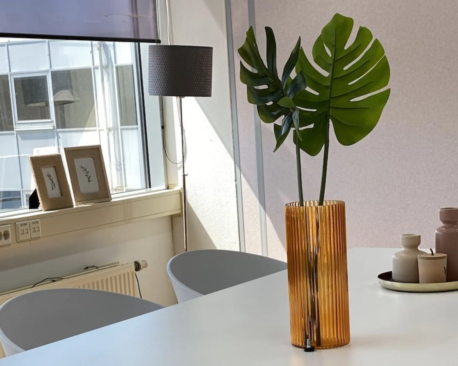 Modern ingerichte kantoorruimte aan de Kamerlingh Onnesweg 10 in Barendrecht met een tafeldecoratie van een oranje vaas en groene bladeren.