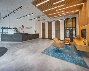 Moderne entreehal met receptiebalie, zithoek en liften in kantoorruimte aan het Prins Alexanderplein 5-21 in Rotterdam.