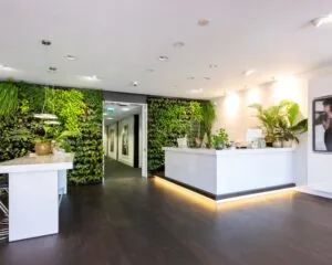 Moderne kantoorruimte met receptiebalie, groene plantenwand en strakke inrichting in Stammerhove 1, Diemen.