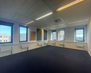 Lichte, lege kantoorruimte met meerdere ramen aan de Zekeringstraat 17 in Amsterdam.