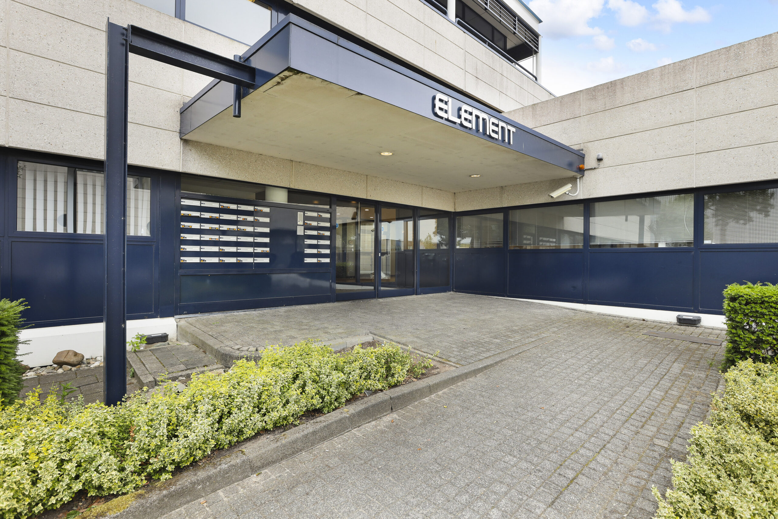 De ingang van Element Offices aan Markerkant 13 in Almere met planten langs het pad.