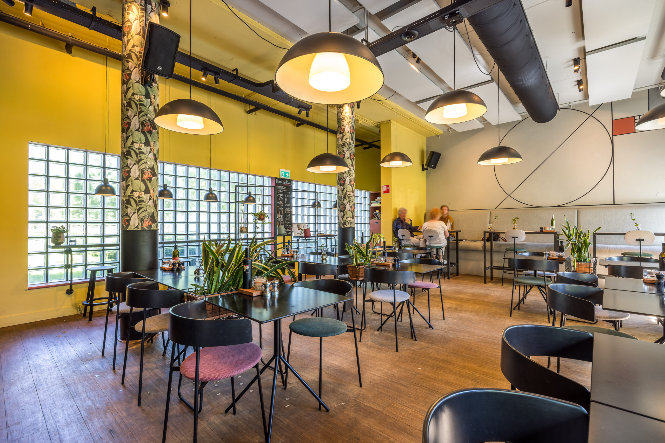 Interieur van Restaurant 13 in Element Offices, Utrecht, met moderne zwarte meubels en hanglampen.