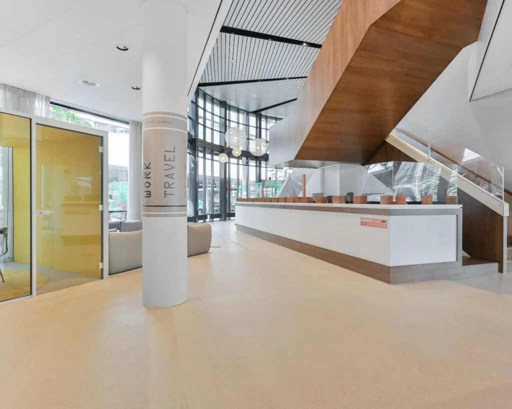 Moderne entree van kantoorruimte aan Weena 209 in Rotterdam met receptiebalie, zithoek en glazen vergaderruimte.