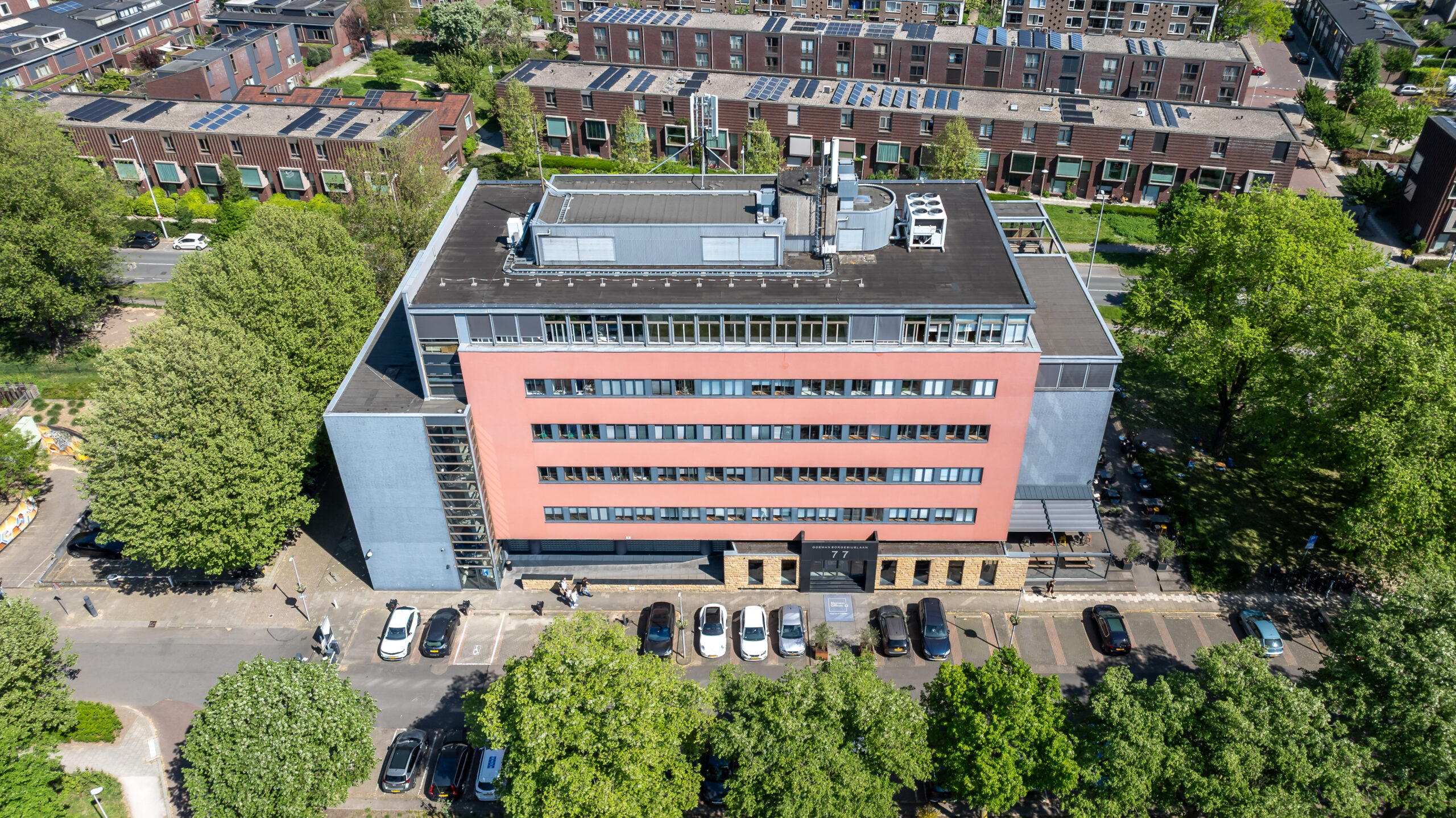 Luchtfoto van Element Offices, een modern gebouw aan de Goeman Borgesiuslaan 77 in Utrecht, omgeven door groen en geparkeerde auto's.