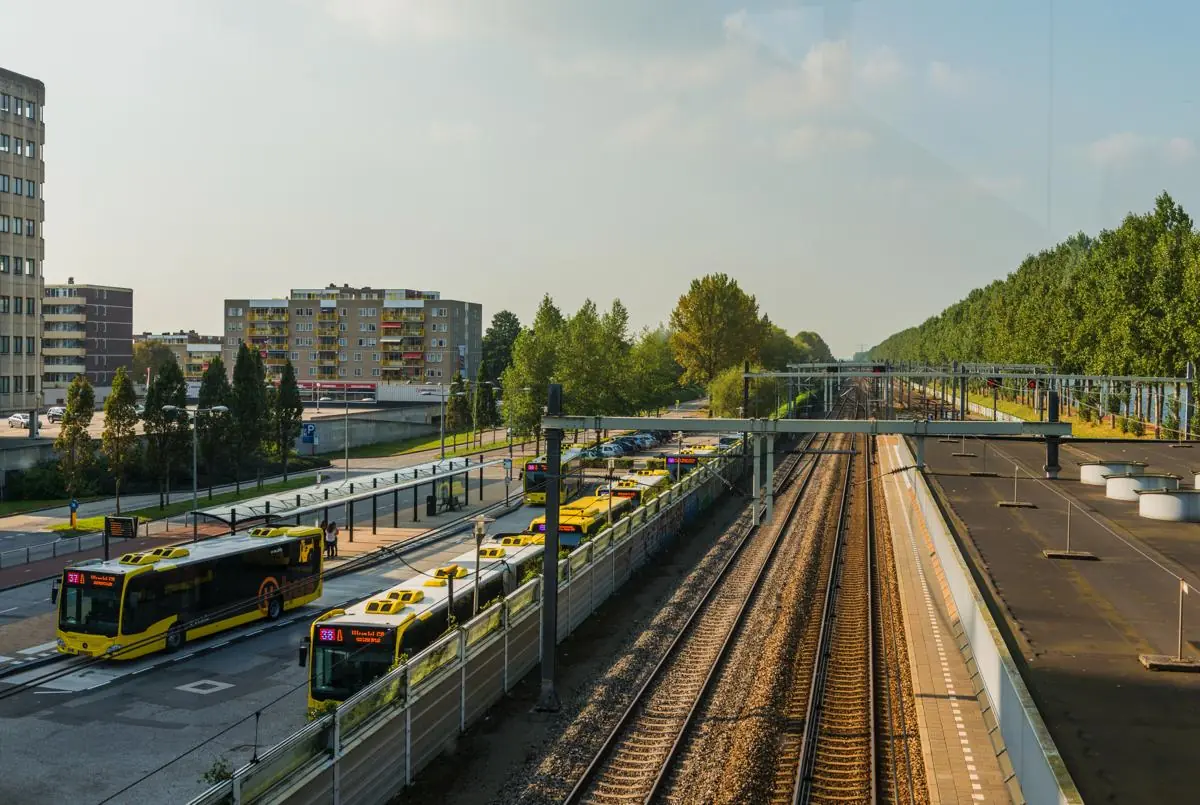 Busstation en treinsporen bij halte Bisonspoor in Maarssen op een zonnige dag.
