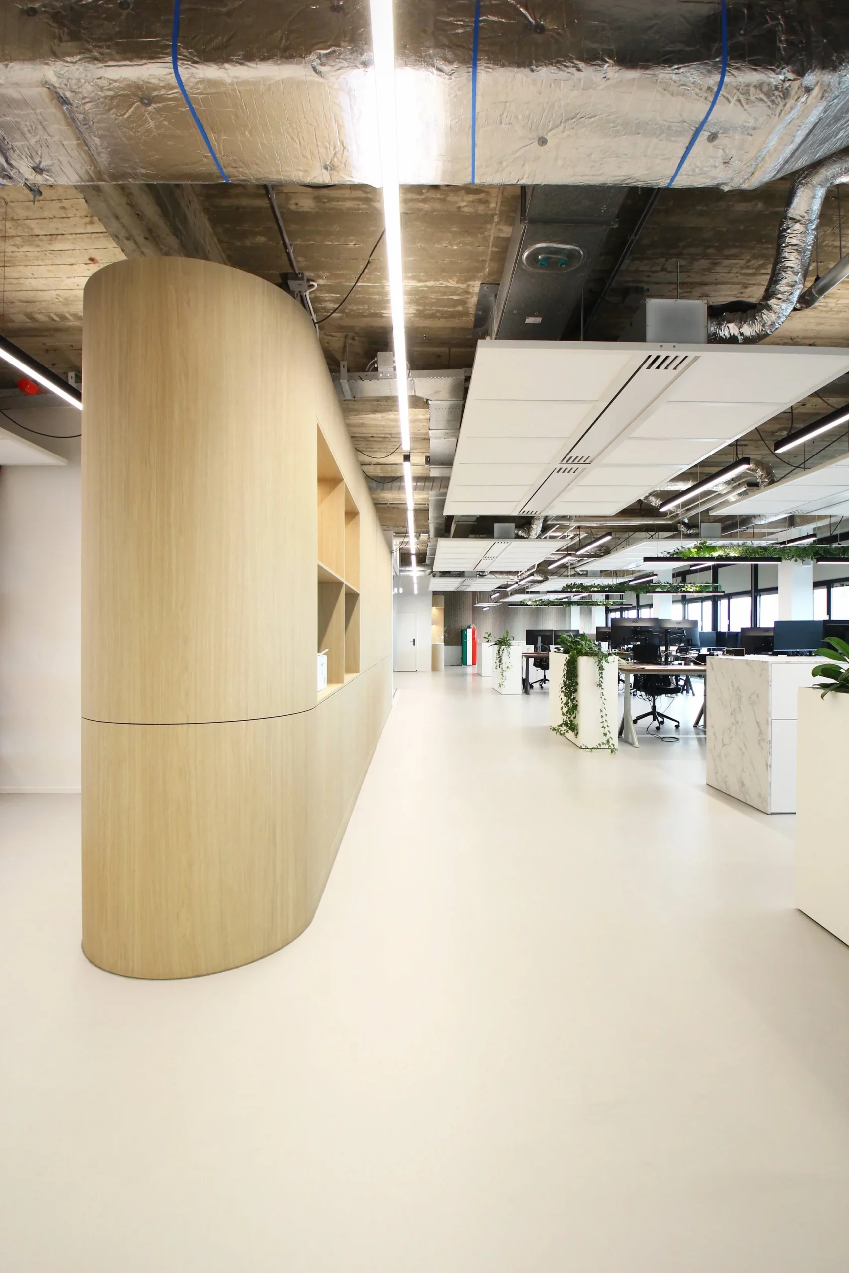 Een modern kantoorinterieur met houten en marmeren elementen en groene planten.