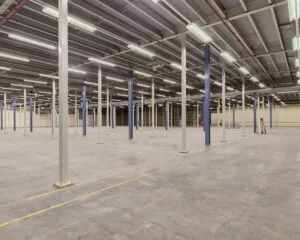 Ruime, lege bedrijfshal met metalen steunpilaren aan de Albert Einsteinweg 5 in Lelystad.