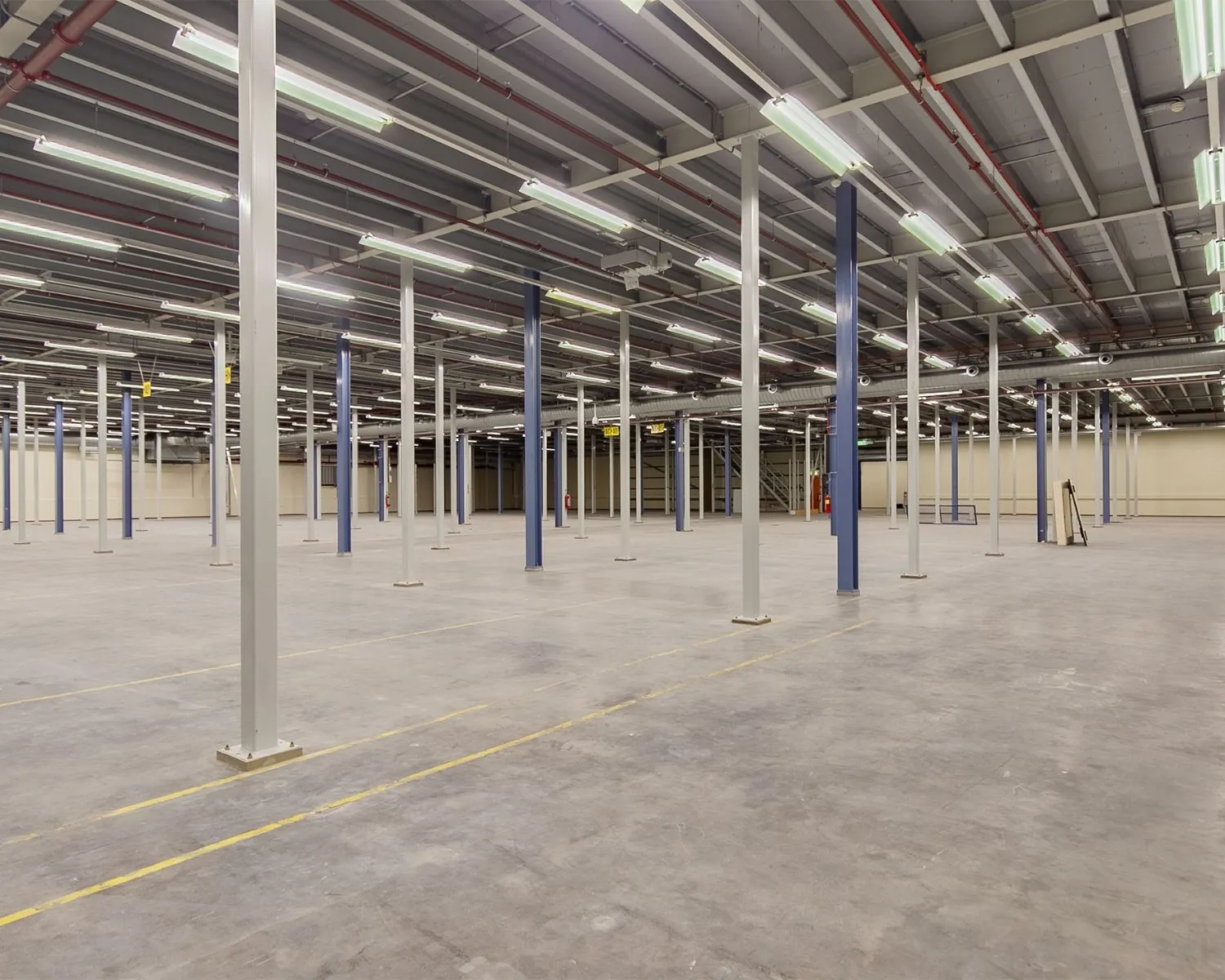 Ruime, lege bedrijfshal met metalen steunpilaren aan de Albert Einsteinweg 5 in Lelystad.