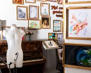 Kunstzinnige kantoorruimte in Almere met schilderijen, een piano en een paspop.