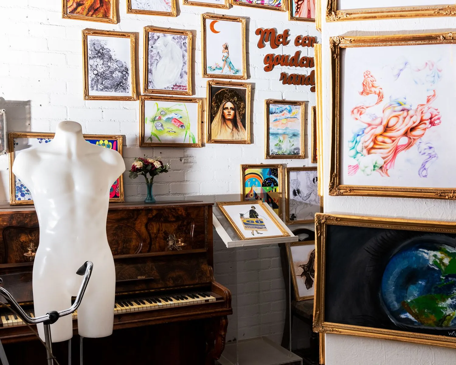 Kunstzinnige kantoorruimte in Almere met schilderijen, een piano en een paspop.