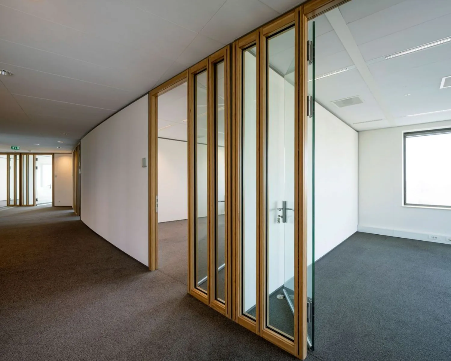 Moderne kantoorruimte met glazen schuifdeuren en tapijtvloer aan de Laan van Langerhuizen 1 in Amstelveen.