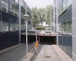 Ingang naar een ondergrondse parkeergarage tussen moderne kantoorgebouwen aan de Reeuwijkse Poort 114 in Reeuwijk.