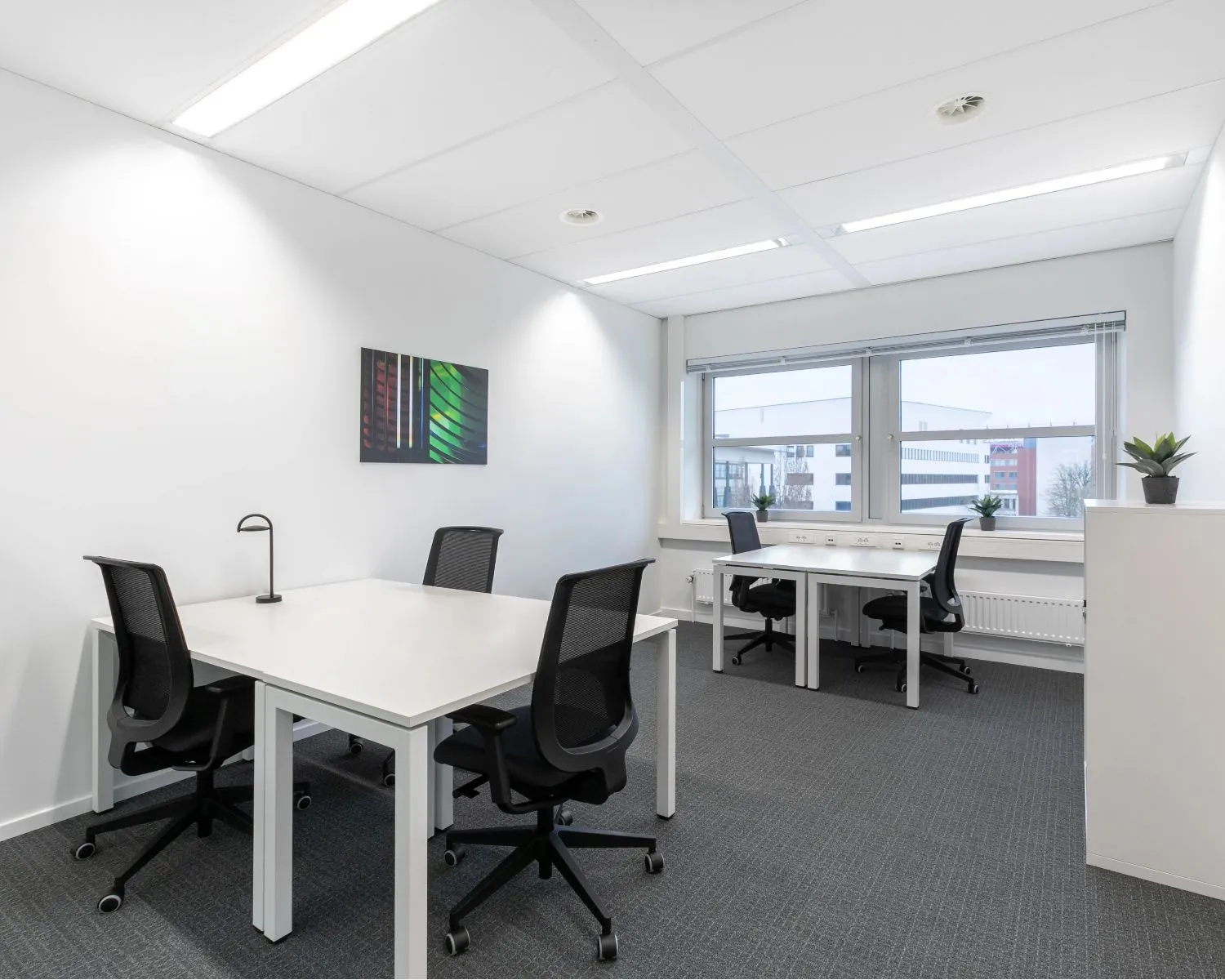 Moderne, lichte kantoorruimte met vier bureaus en ergonomische stoelen in Capitool 10 in Enschede.