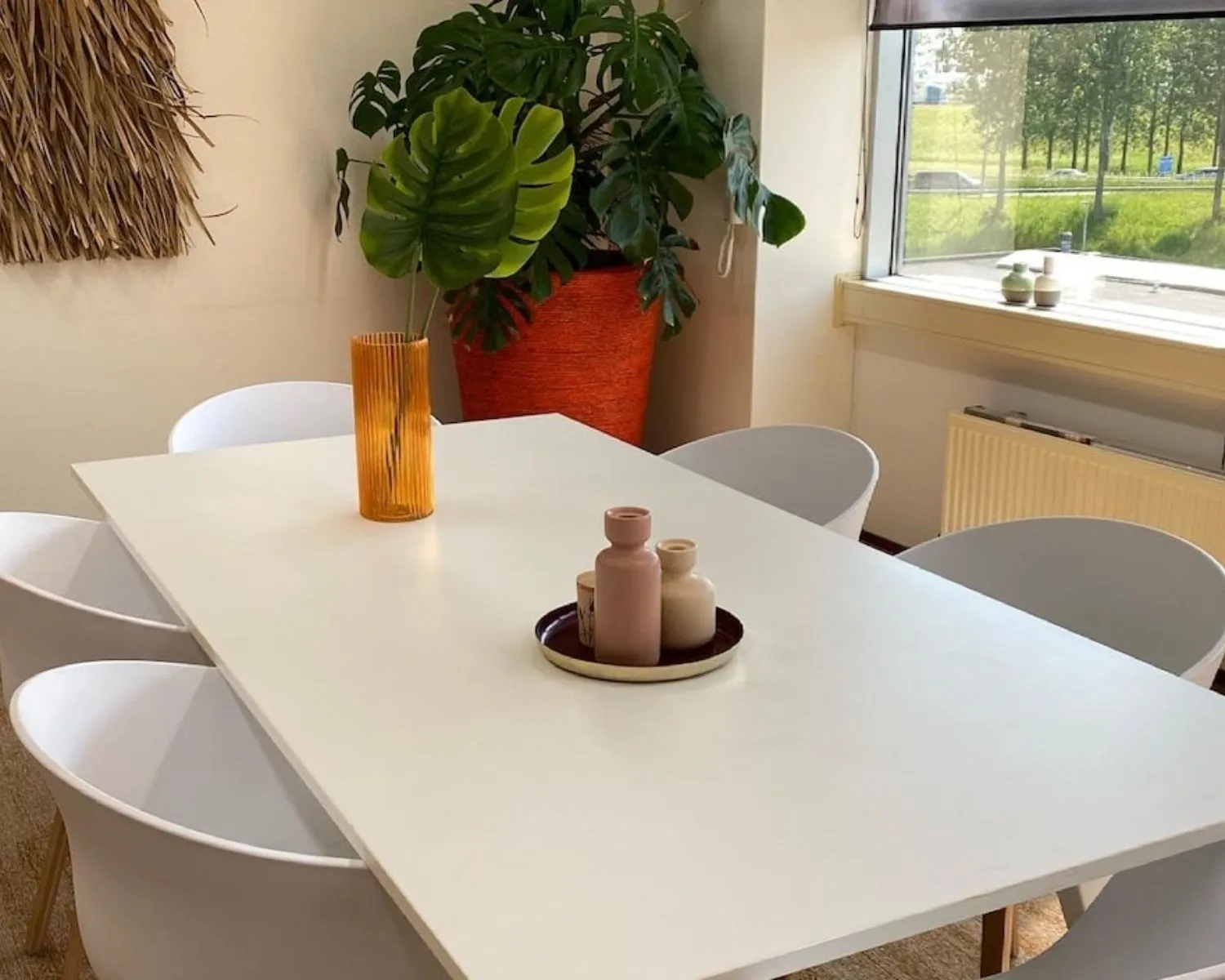 Moderne kantoorruimte aan de Kamerlingh Onnesweg 10 in Barendrecht met een witte vergadertafel, designstoelen en decoratieve planten.