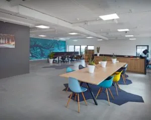 Moderne kantoorruimte met flexwerkplekken, een grote vergadertafel en kleurrijke stoelen op Prins Alexanderplein 5-21 in Rotterdam.