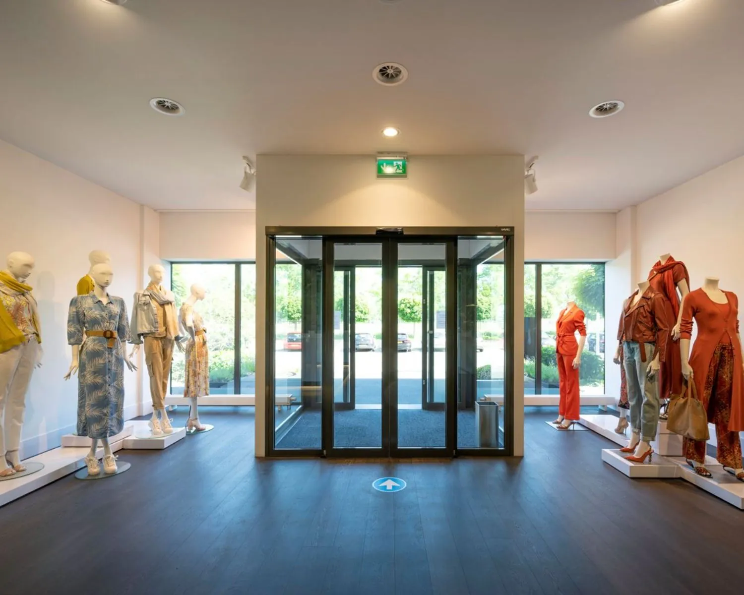 Ingerichte entreehal van kantoorruimte Stammerhove 1 in Diemen met etalagepoppen in moderne kleding aan weerszijden van de glazen schuifdeur.