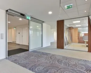 Moderne kantoorruimte aan de Treubstraat 1 in Rijswijk met glazen wanden, houten accenten en tapijtvloer.