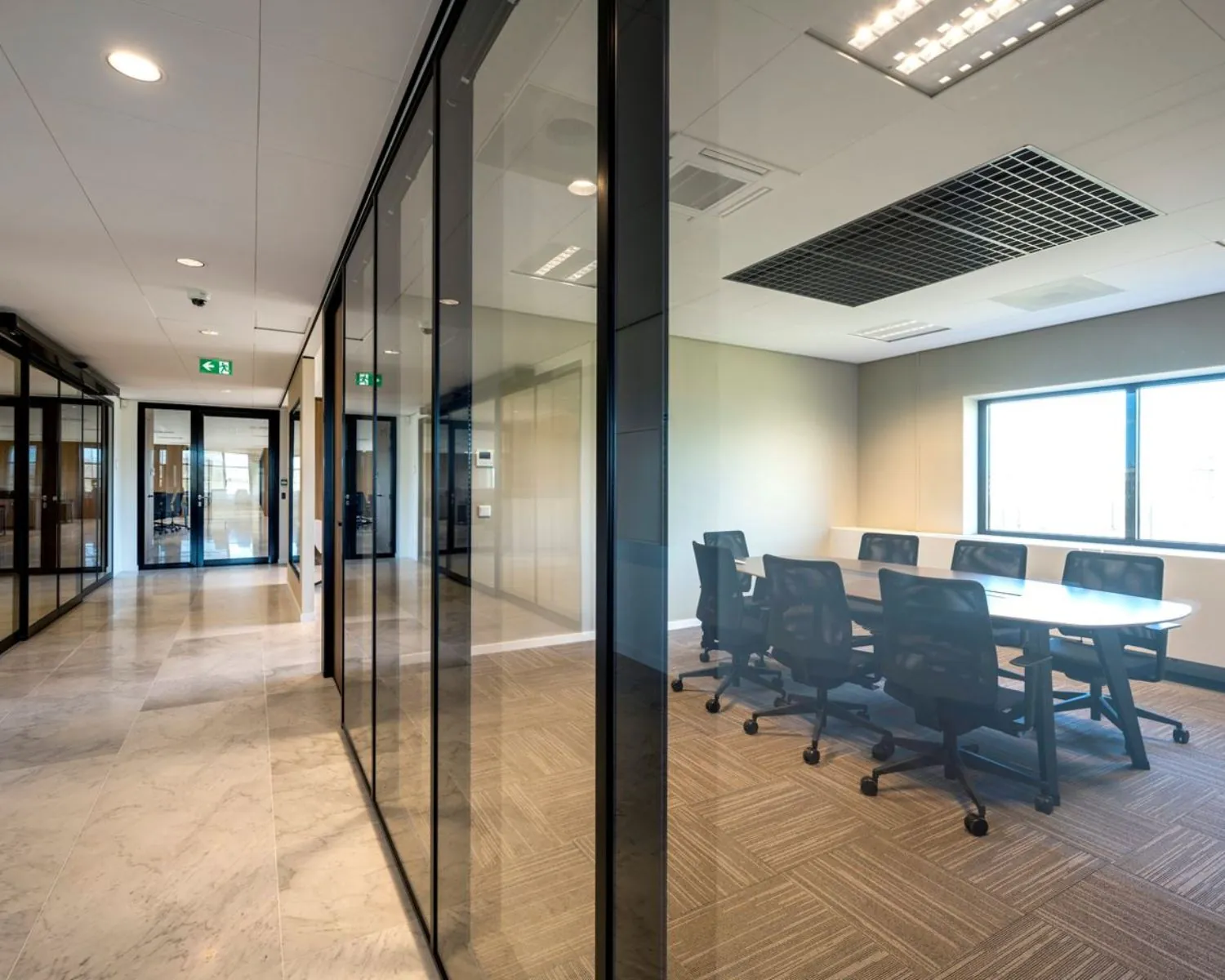 Moderne kantoorruimte met glazen wanden en een vergaderruimte aan de Wegalaan 35 in Hoofddorp.