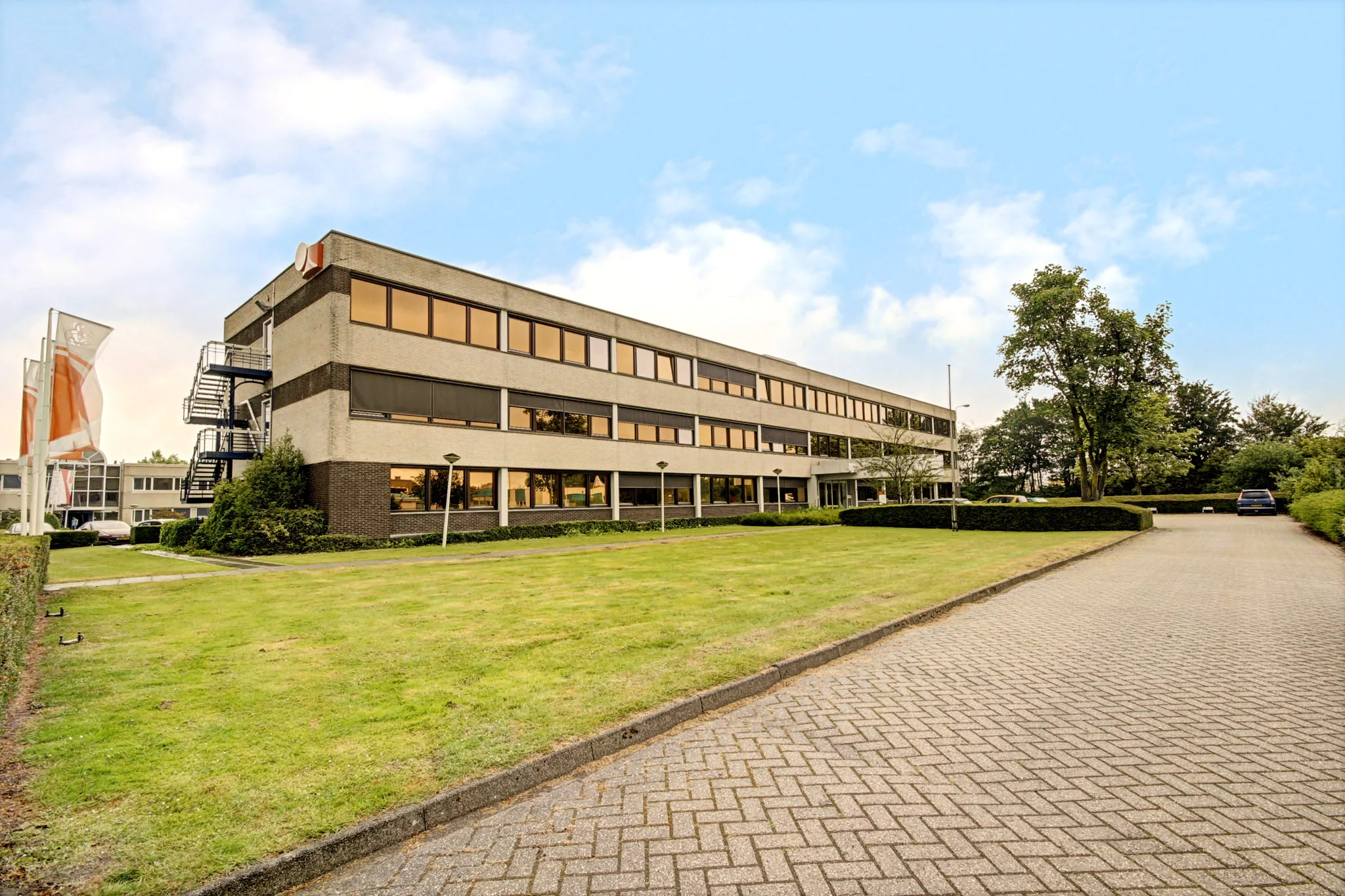 Kantoorgebouw aan de Maarssenbroeksedijk met parkeerplaats en goed onderhouden groenstrook.