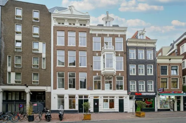 Voorgevel van een rij Amsterdamse panden aan de straatzijde, waaronder het gebouw 419_2160 met grote ramen en een erker.