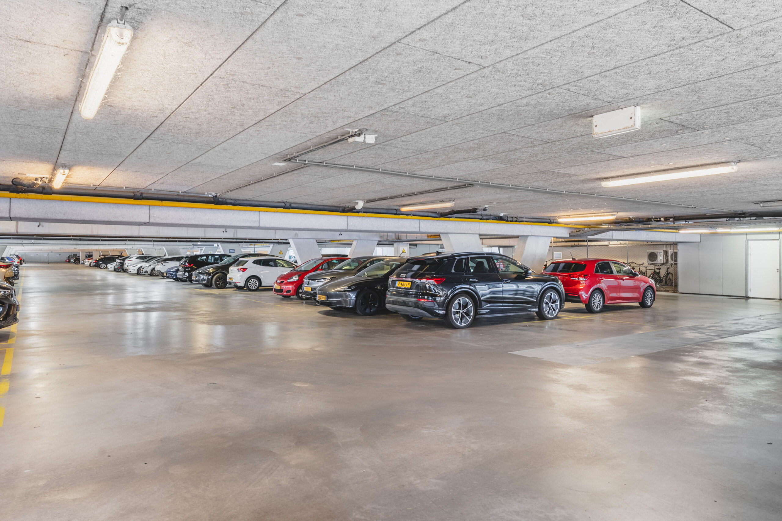 Interieur van parkeergarage Rijnzathe met verschillende geparkeerde auto’s.