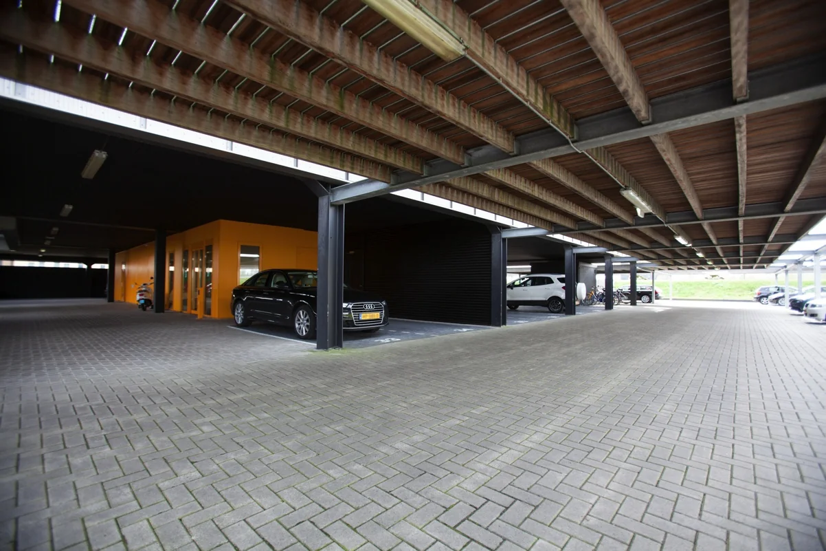 Overdekte parkeergarage aan de Orteliuslaan met geparkeerde auto's en een opvallende gele entree.
