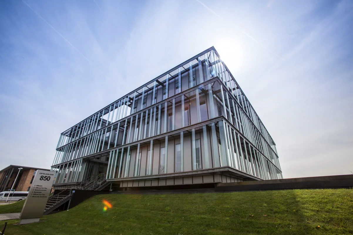 Modern kantoorpand aan de Orteliuslaan 850 met glazen gevel en zonlicht op de achtergrond.