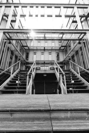 Zwart-witfoto van een moderne metalen buitentrap naar een hoger gelegen entree aan de Orteliuslaan.