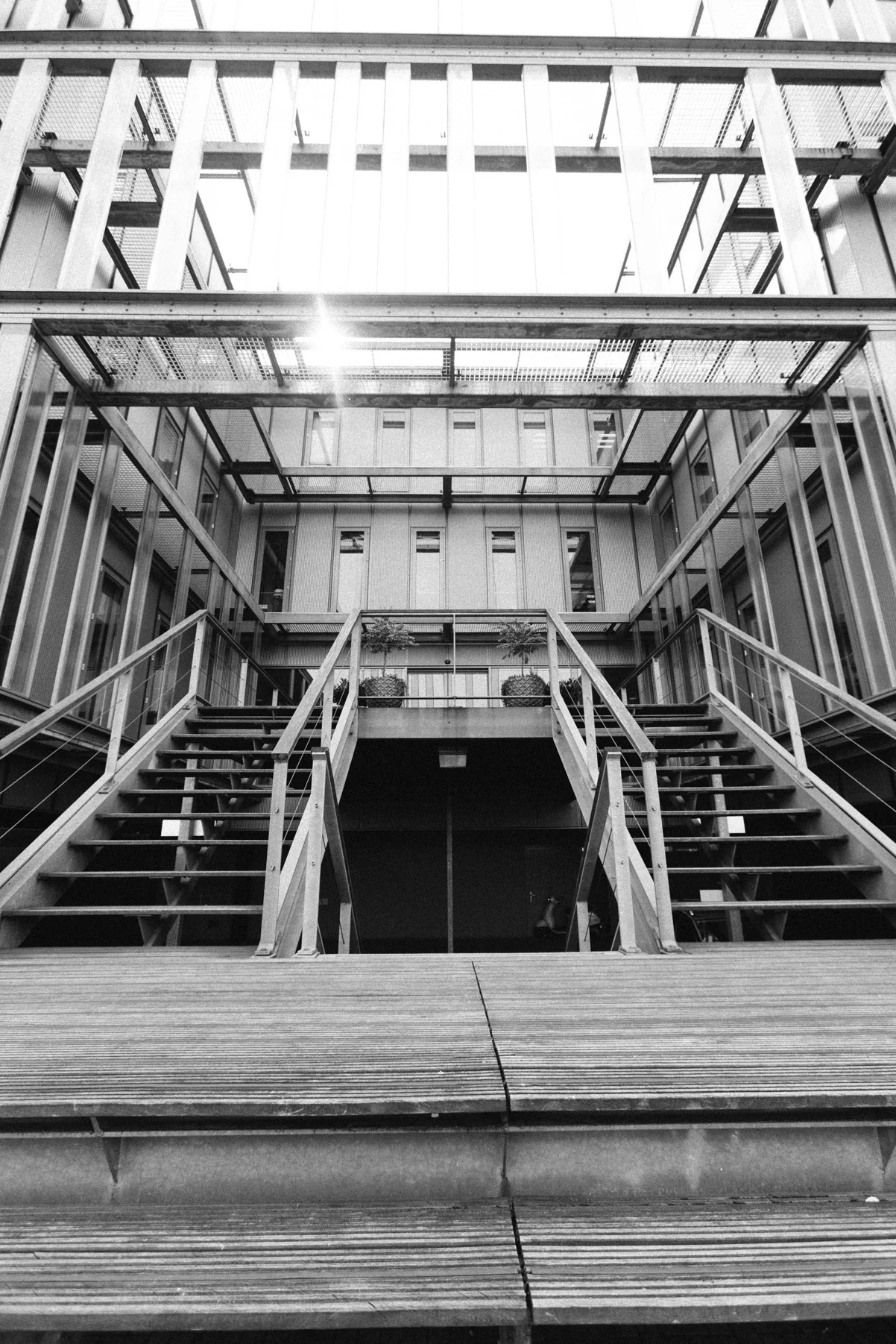 Zwart-witfoto van een moderne metalen buitentrap naar een hoger gelegen entree aan de Orteliuslaan.