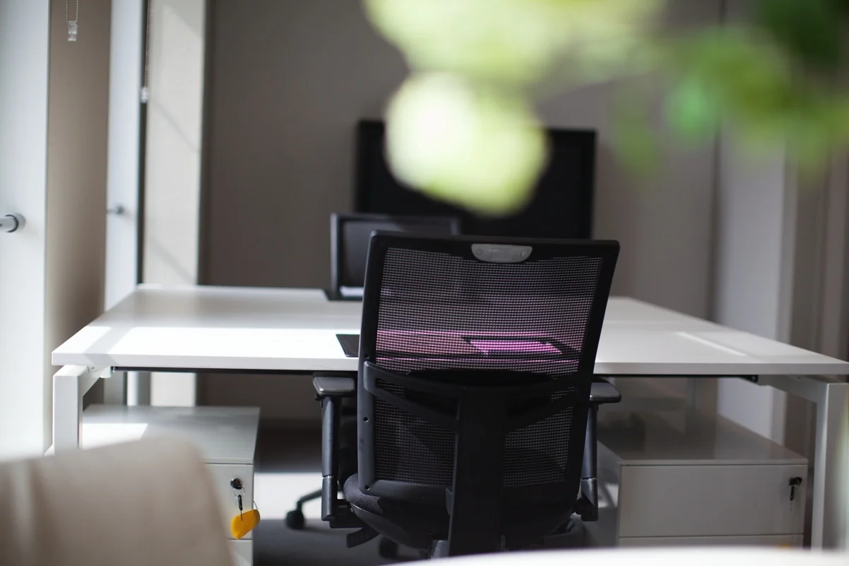 Modern kantoor met witte bureaus, zwarte bureaustoelen en laptops aan de Orteliuslaan.