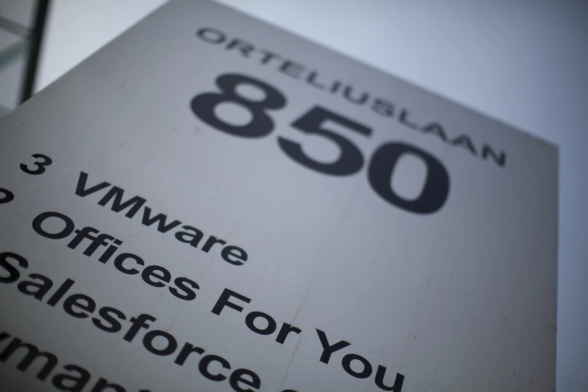 Wit bedrijfsnaambord met huisnummer 850 aan de Orteliuslaan, met namen van bedrijven zoals VMware en Salesforce.