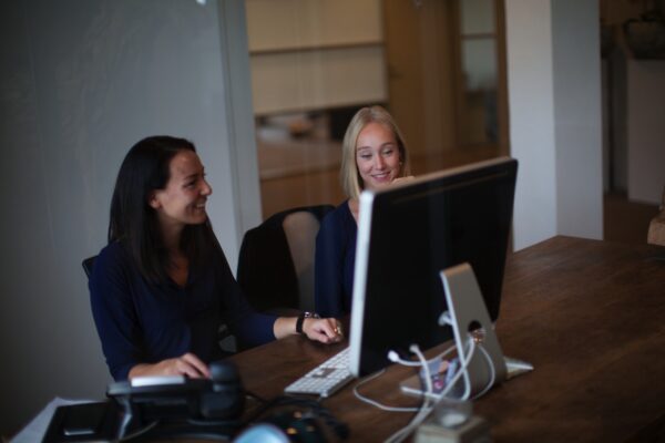 Twee vrouwen werken samen achter een computer op een kantoor aan de Orteliuslaan.