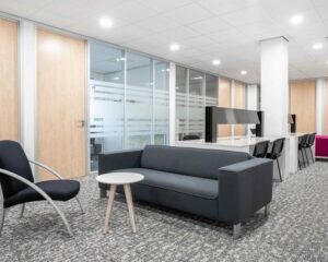 Moderne kantoorruimte aan de Hurksestraat 43 in Eindhoven met zithoek, bureaus en glazen scheidingswanden.