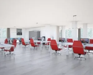 Moderne kantoorruimte aan de Bolderweg 1 in Almere met open werkplekken en rode bureaustoelen.