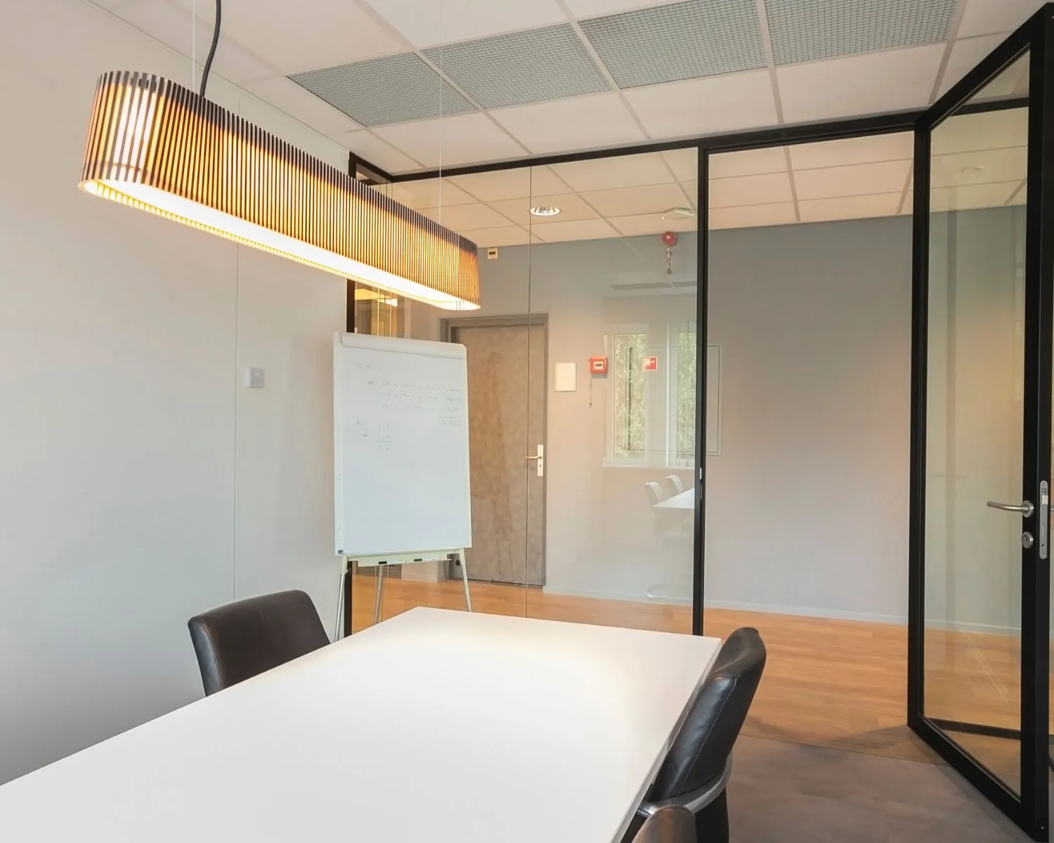 Moderne vergaderruimte op Bolderweg 2a in Almere met glazen wanden, whiteboard en designverlichting.