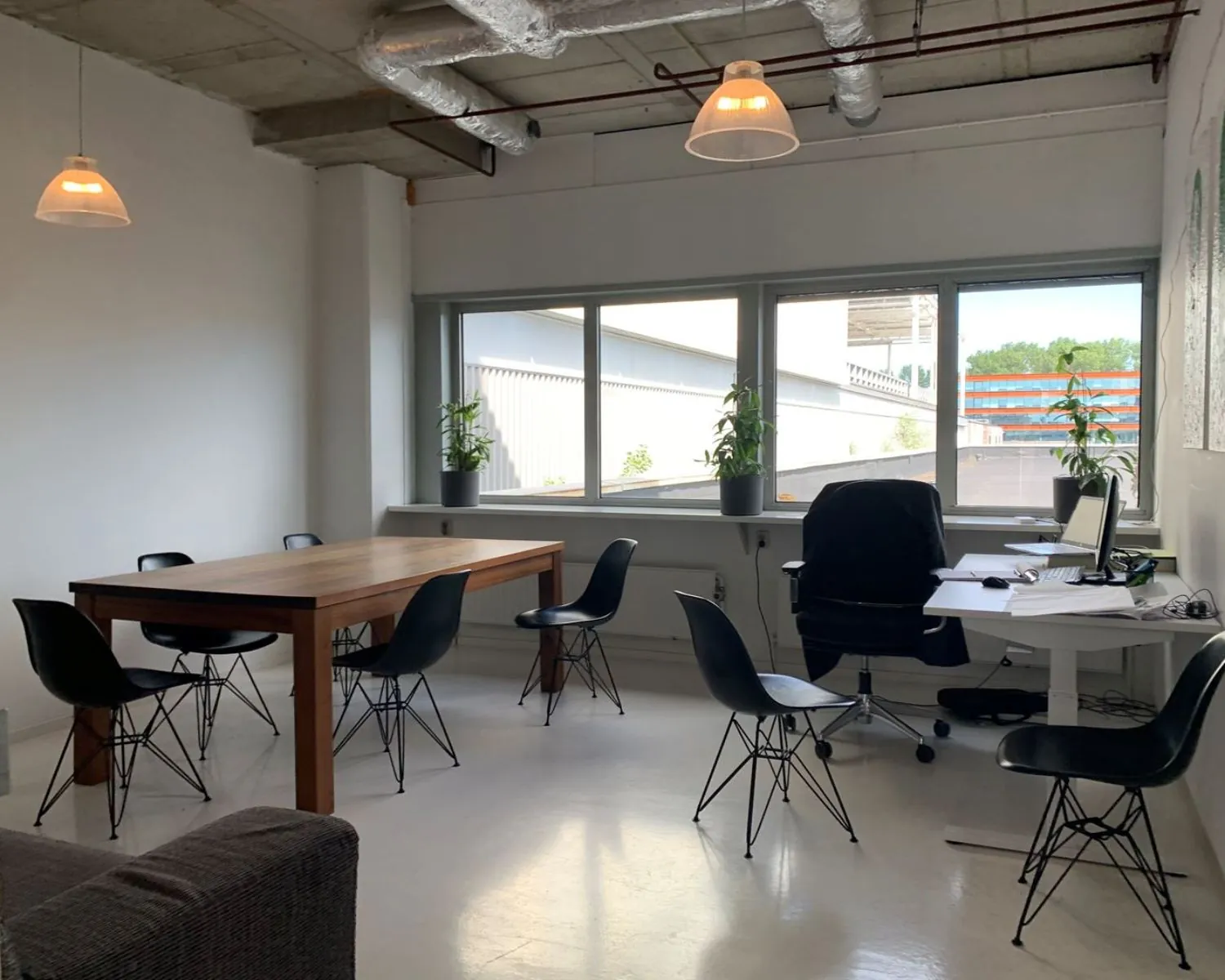 Moderne kantoorruimte met vergadertafel, werkplek en grote ramen aan de Anthony Fokkerweg 21 in Amsterdam.