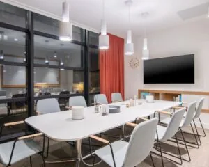 Moderne vergaderruimte in een kantoor aan Schimmelt 2-16 in Eindhoven met strakke inrichting, grote tafel, en een wandtelevisie.