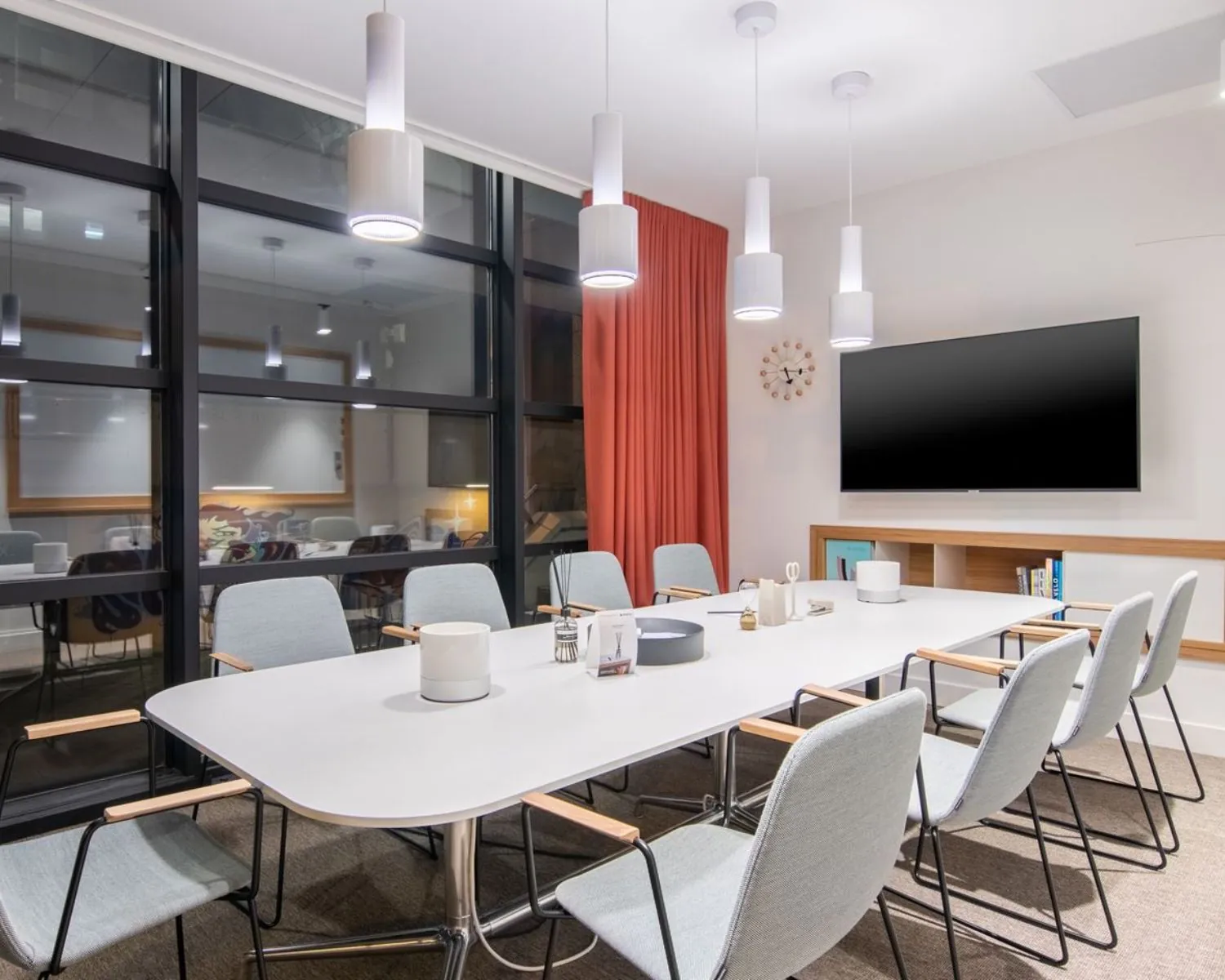Moderne vergaderruimte in een kantoor aan Schimmelt 2-16 in Eindhoven met strakke inrichting, grote tafel, en een wandtelevisie.
