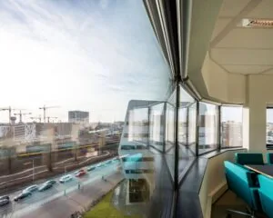 Vergaderruimte met grote ramen en uitzicht op het spoor en de stad bij Rietlandpark 301 in Amsterdam.