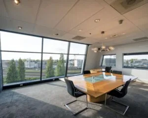 Moderne vergaderruimte met grote ramen en uitzicht op Rietlandpark in Amsterdam.
